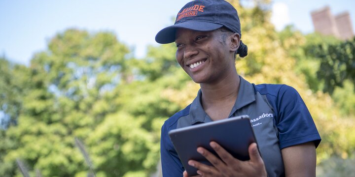 Student holding an ipad and smiling