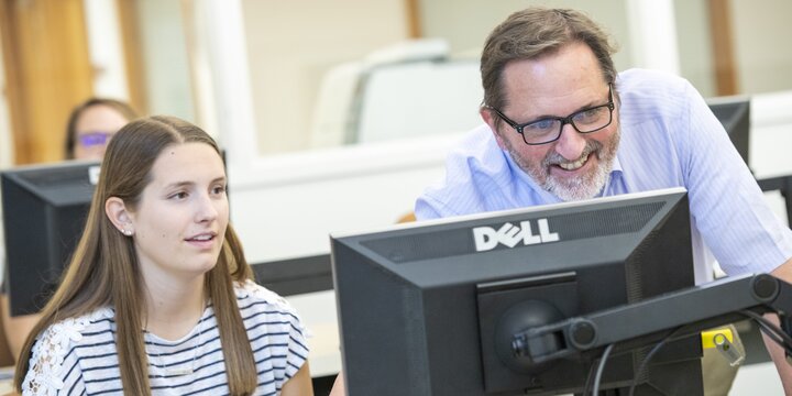 Instructor working with student and a computer